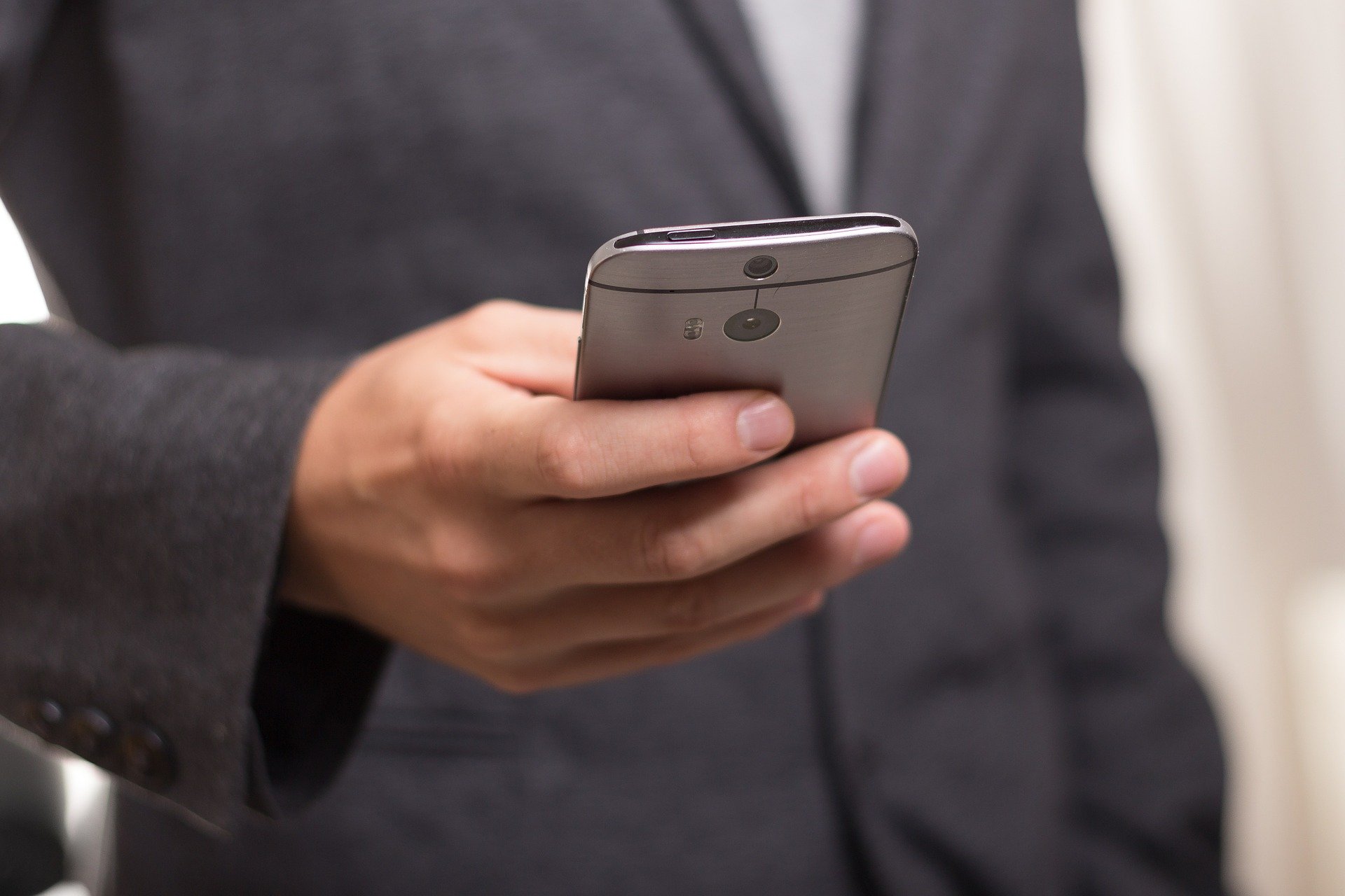 un businessman en costume consultant son téléphone portable