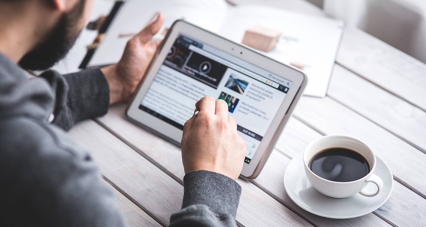 un homme regardant les actualités sur sa tablette