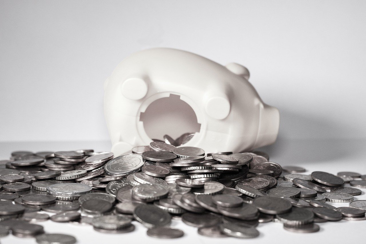 cochon tirelire qui se vide de sa monnaie pour montrer une perte dans l'économie